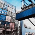 Contenedores de exportación en un puerto comercial, mientras México negocia con Estados Unidos la exclusión de aranceles para productos protegidos por el T-MEC.
